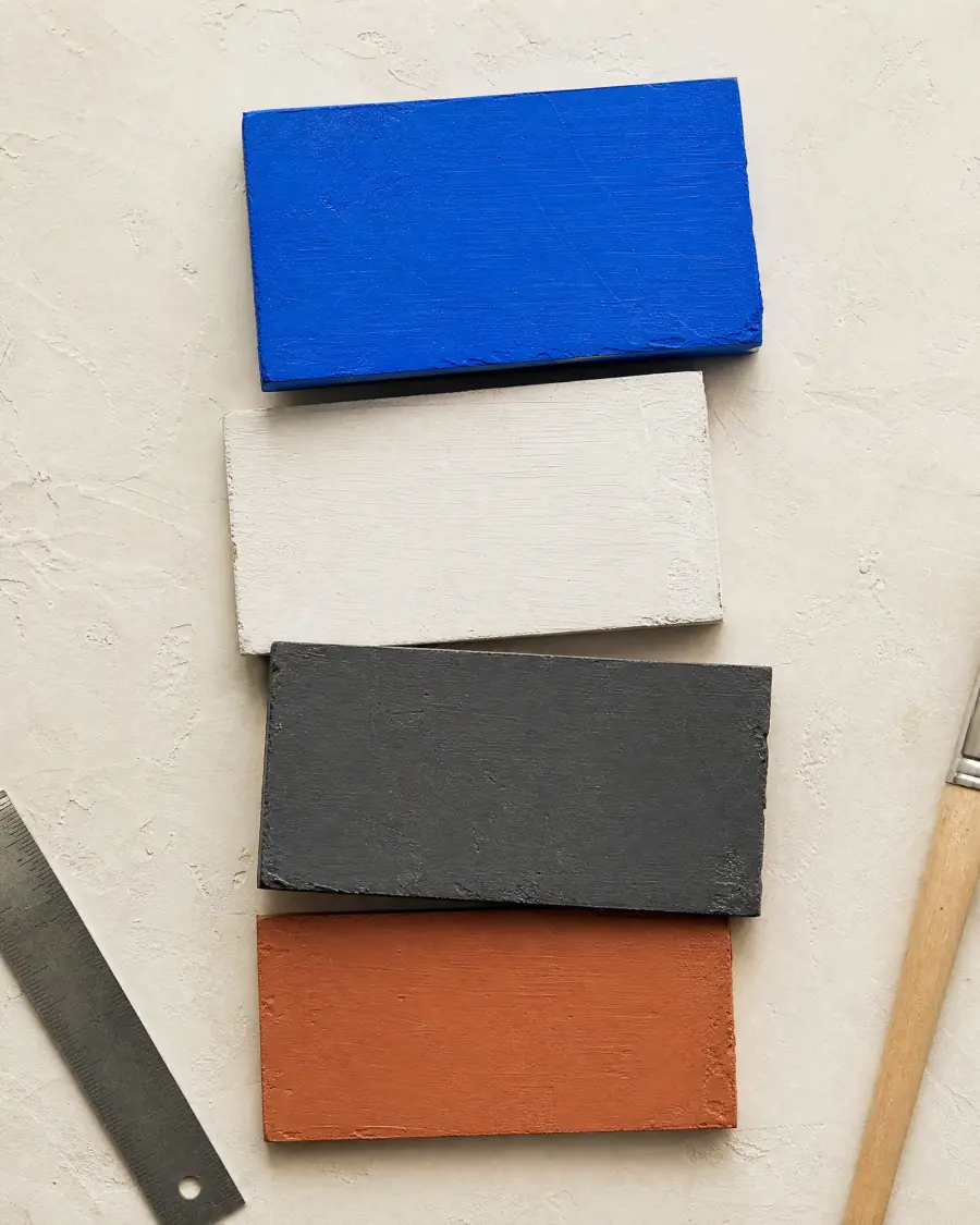 Muestras de pigmentos azul, blanco, negro y arcilla con una regla metálica